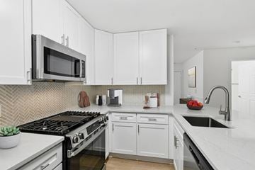 Owings Mills apartment for rent - A kitchen with white cabinets and a black stove top.