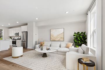Brooklyn apartment for rent - A modern living room with a white sofa, a coffee table, and a large painting on the wall.