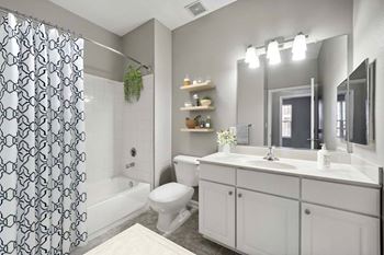A bathroom with a white toilet, sink, and a shower with a black and white curtain