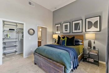 A bedroom with a bed, a nightstand, and a mirror.