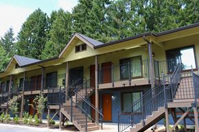 Portland apartment for rent - A yellow building with a balcony and stairs leading to the second floor.