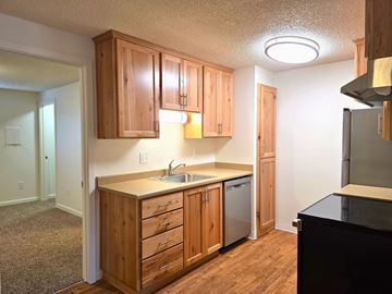 Portland apartment for rent - A kitchen with wooden cabinets and a black counter.