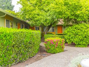 Milwaukie apartment for rent - a house with hedges and flowers in front of it