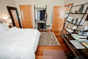 Portland apartment for rent - a bedroom with a white bed and a closet with clothes on it
