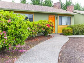 Milwaukie apartment for rent - a sidewalk in front of a green house with a orange door