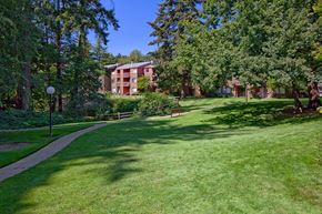 Milwaukie apartment for rent - a grassy area with trees and buildings in the background