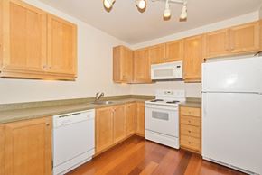 Portland apartment for rent - a kitchen with white appliances and wooden cabinets