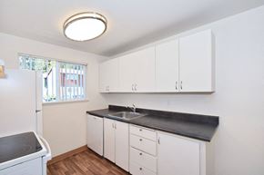 Milwaukie apartment for rent - a kitchen with white cabinets and a sink and a window