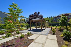 Tigard apartment for rent - A gazebo is surrounded by a garden with a paved walkway.