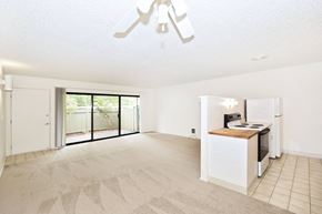 Milwaukie apartment for rent - an empty living room with a kitchen and a sliding glass door