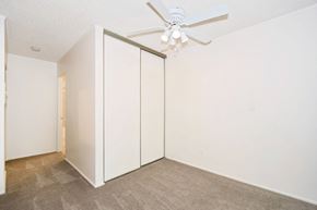 Milwaukie apartment for rent - a bedroom with white walls and a ceiling fan