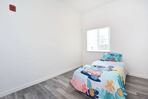 Chico apartment for rent - a bedroom with white walls and a bed with a colorful bedspread and a window