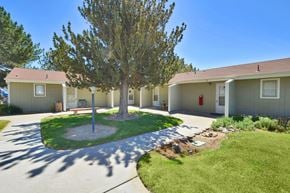 Nyssa apartment for rent - A tree in the middle of a grassy area in front of a building.