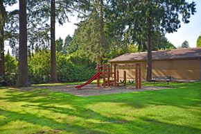 Beaverton apartment for rent - A playground with a red slide and a wooden structure.
