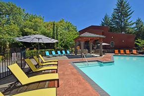 Portland apartment for rent - A pool area with a red building and yellow sun loungers.