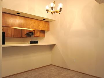 Gladstone apartment for rent - A kitchen area with wooden cabinets and a chandelier.