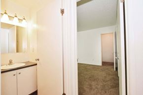 Portland apartment for rent - a bathroom with a sink and a mirror and a hallway to a bedroom