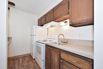 Beaverton apartment for rent - a kitchen with white appliances and wooden cabinets