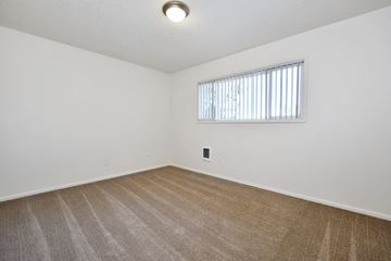 Beaverton apartment for rent - a spacious living room with carpet and a window