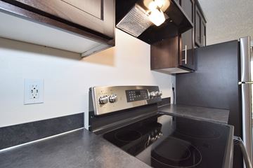 Hillsboro apartment for rent - a kitchen with black counter tops and a stove top oven and