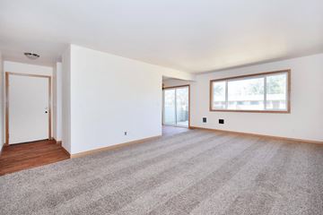 Tigard apartment for rent - the living room and dining room of a house with carpet and a window