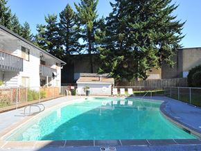 Beaverton apartment for rent - a swimming pool in front of a house with trees