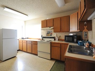 Lincoln City apartment for rent - a kitchen with white appliances and wooden cabinets