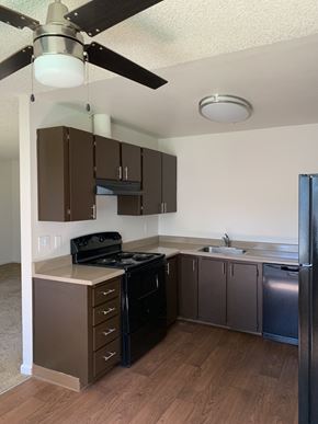 Gladstone apartment for rent - A kitchen with a black stove top oven and a black refrigerator.