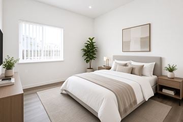 Chico apartment for rent - A bedroom with a large bed and a potted plant on the nightstand.