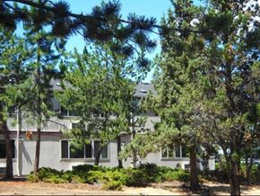 Bend apartment for rent - a white house with trees in front of it