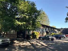 Beaverton apartment for rent - A black car is parked on the street in front of a building.