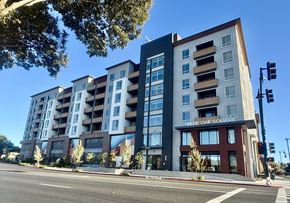 Concord apartment for rent - A modern multi-story building named Blue Oak Solitaire is situated on a street corner.