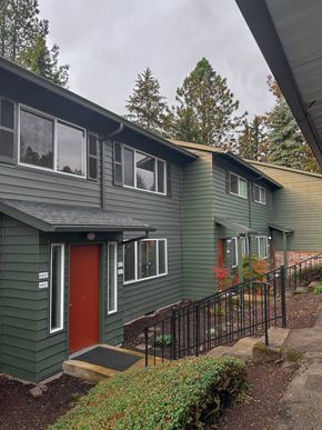 Portland apartment for rent - A green house with a red door and a black fence.