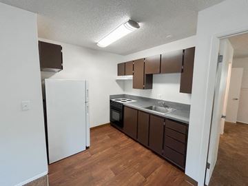 Portland apartment for rent - A kitchen with brown cabinets and a white refrigerator.