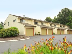 Gladstone apartment for rent - a street view of a yellow building with a parking lot