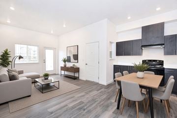 Chico apartment for rent - A modern living room with a grey sofa, a coffee table, and a dining table with grey chairs.