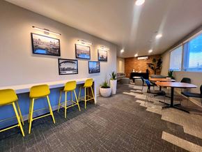 Pittsburg apartment for rent - a lounge area with yellow chairs and tables and a piano