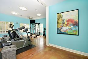 Portland apartment for rent - A gym with a treadmill, elliptical machines, and a painting on the wall.