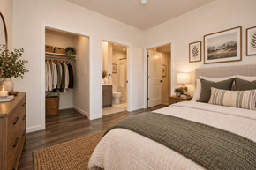 Gridley apartment for rent - A bedroom with a large bed and a closet with clothes hanging.
