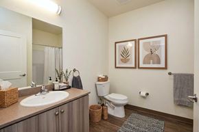 Gridley apartment for rent - A bathroom with a toilet, sink, and mirror.