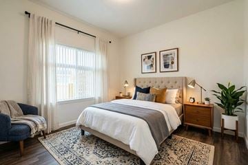 Gridley apartment for rent - A bedroom with a large bed and a blue chair.