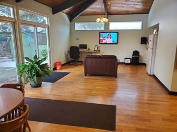 Bend apartment for rent - A living room with a brown couch and a television mounted on the wall.