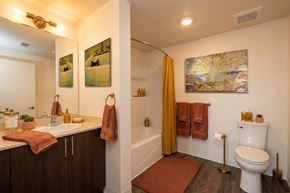 Oroville apartment for rent - A bathroom with a toilet, sink, and a painting on the wall.