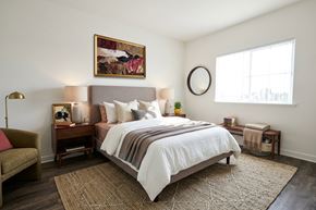 Oroville apartment for rent - A bedroom with a large bed and a painting on the wall.
