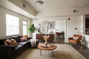 Oroville apartment for rent - A living room with a grey couch, a brown armchair, a wooden coffee table, and a rug.