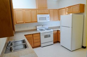 Winters apartment for rent - a kitchen with white appliances and wooden cabinets