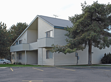 Ontario apartment for rent - A grey building with a parking lot in front.