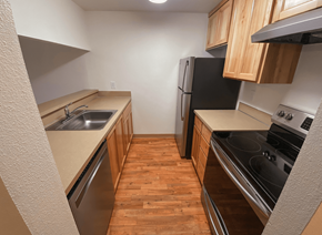 Beaverton apartment for rent - a small kitchen with wood flooring and stainless steel appliances