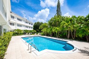 Boca Raton apartment for rent - A small pool surrounded by trees and a white building.
