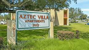 Panama City apartment for rent - A sign for Aztec Villa Apartments stands in front of a building.